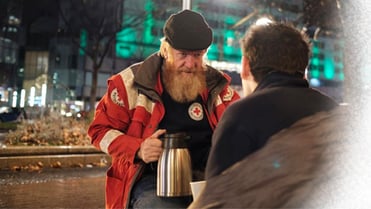 Ein Mann schenkt Getränke an Bedürftige aus