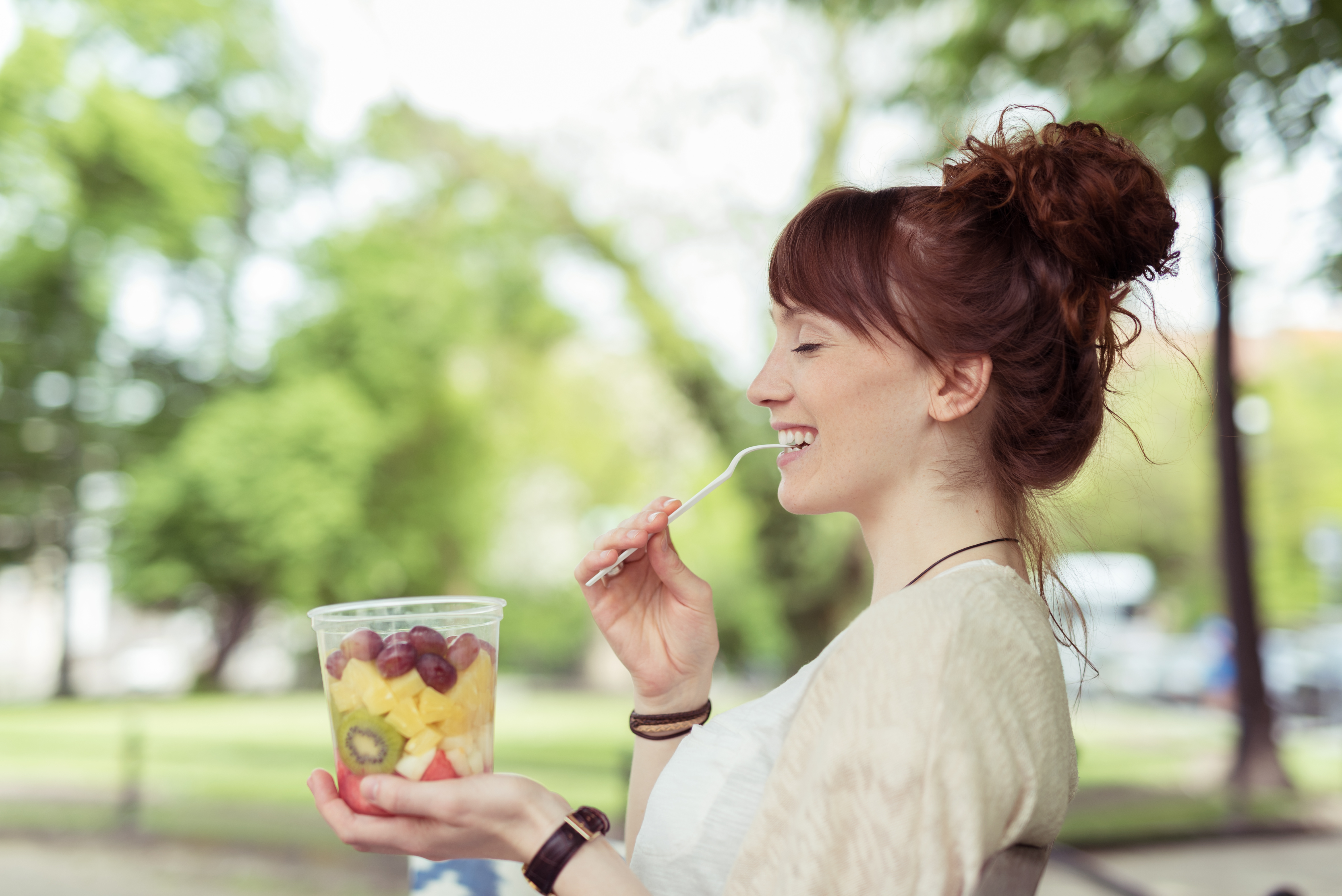 Frau isst einen Obstsalat