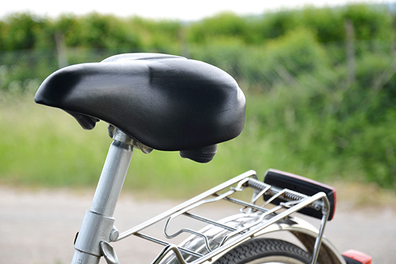 Ein schwarzer Fahradsattel im Hintergrund eine gruenflaeche