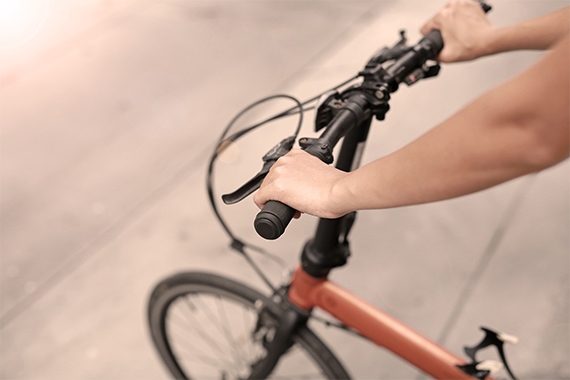 Eine Person haelt den Lenker eines Fahrrads fest
