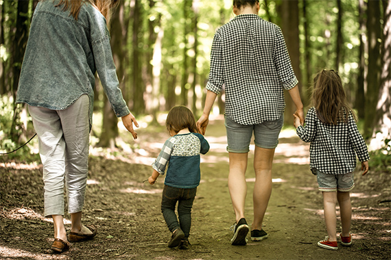Eine Familie geht in einem Wald spazieren Eine Familie geht in einem Wald spazieren