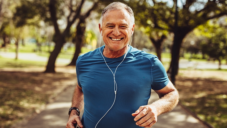 Ein Mann im blauem T-shirt ist in einem Park Joggen