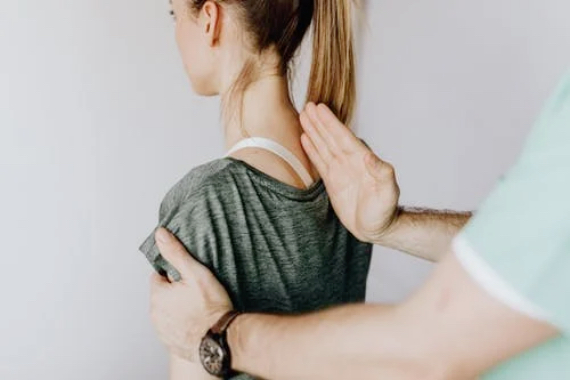 Ein Mann hat seine rechte Handkante auf dem Ruecken einer Frau platziert mit der linken Hand haelt er sie am linken Arm fest Ein Mann hat seine rechte Handkante auf dem Ruecken einer Frau platziert mit der linken Hand haelt er sie am linken Arm fest